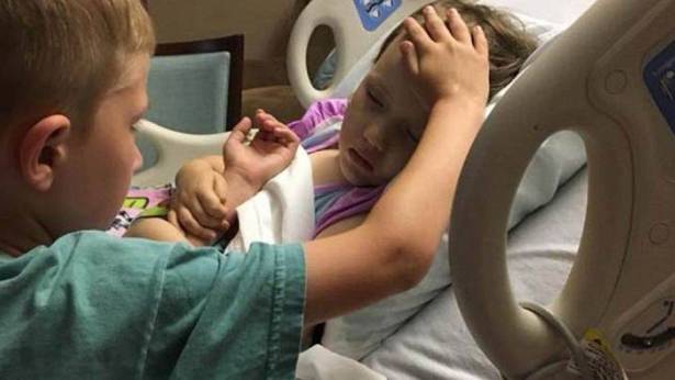 صورة تكسر القلب لطفل يمسح على رأس أخته وهي تحتضر