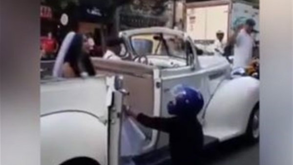 بالفيديو ..  شاب يوقف سيارة زفاف حبيبته ويتوسل أن تعود إليه 