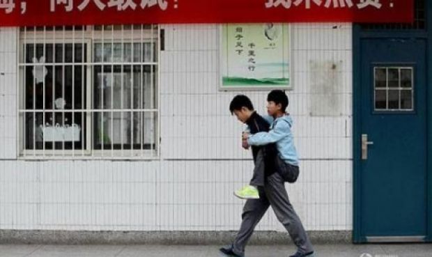 طالب صيني يحمل صديقه المعاق ثلاث سنوات إلى المدرسة