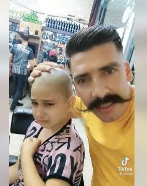 شاهد  ..  كوافير سوري يقص شعر طفلة بسبب المرض وهذا ما فعله عندما بكت !