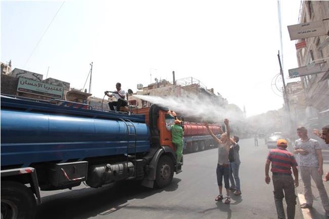بالصور .. رش شوارع عمان بالماء