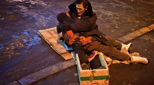 بالصور: صيني يعانق زوجته المتوفاة ساعتين في الشارع