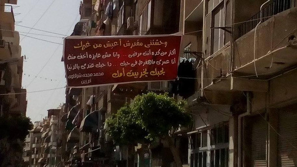 مصرية تصالح زوجها بلافتة كتب عليها "بحبك يخرب بيت أمك"