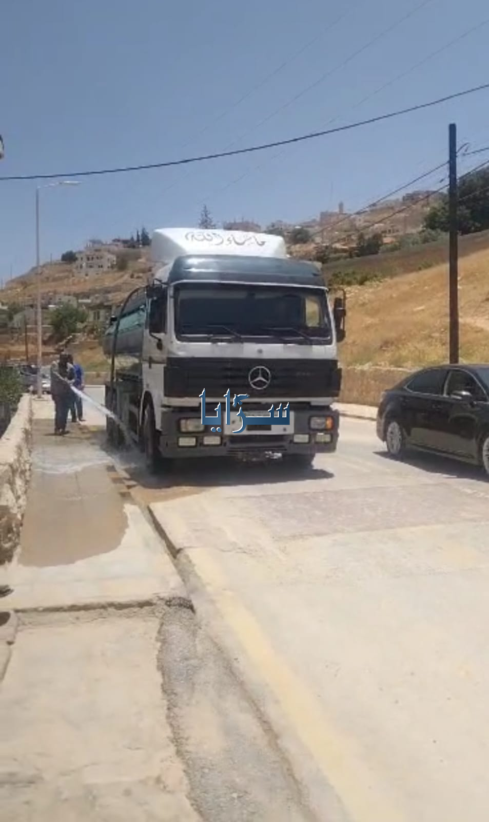 بالصور ..  دليل سياحي يكنس ويغسل شارع بوادي موسى من مخلفات "الشتوة" الأخيرة حفاظاً على سلامة وصحة أسرته