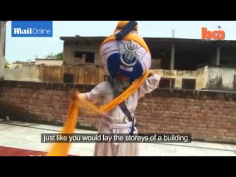 بالفيديو ..  رجل دين هندي يرتدي عمامة طولها 600 متر و وزنها 55 كيلو !