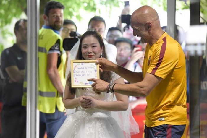بالصور ..  فتاة تفاجئ لاعب روما توتي وتطلب منه الزواج بفستان زفا