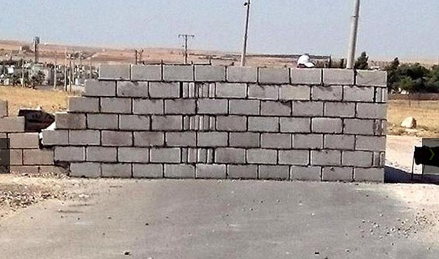 الكرك : مواطن يغلق شارعاً يمر من أرضه بالطوب