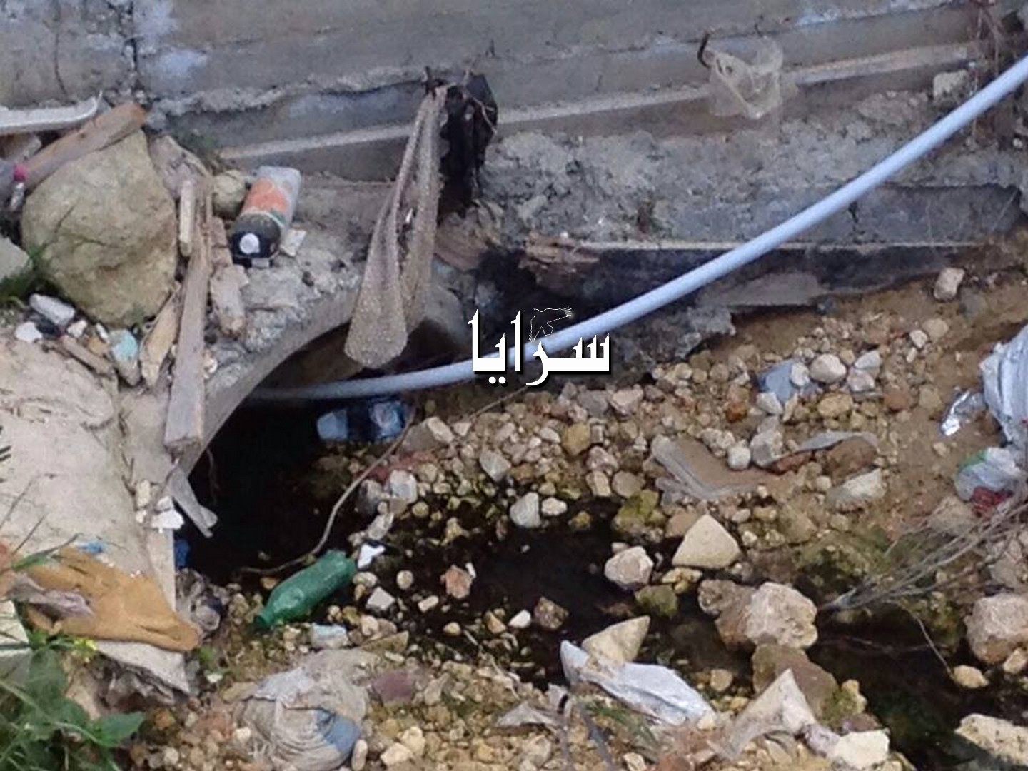 بالصور  ..  مواطن يضخ مياه " المجاري "  داخل عبارة لصرف مياه الامطار  ..  و الأهالي يشتكون 