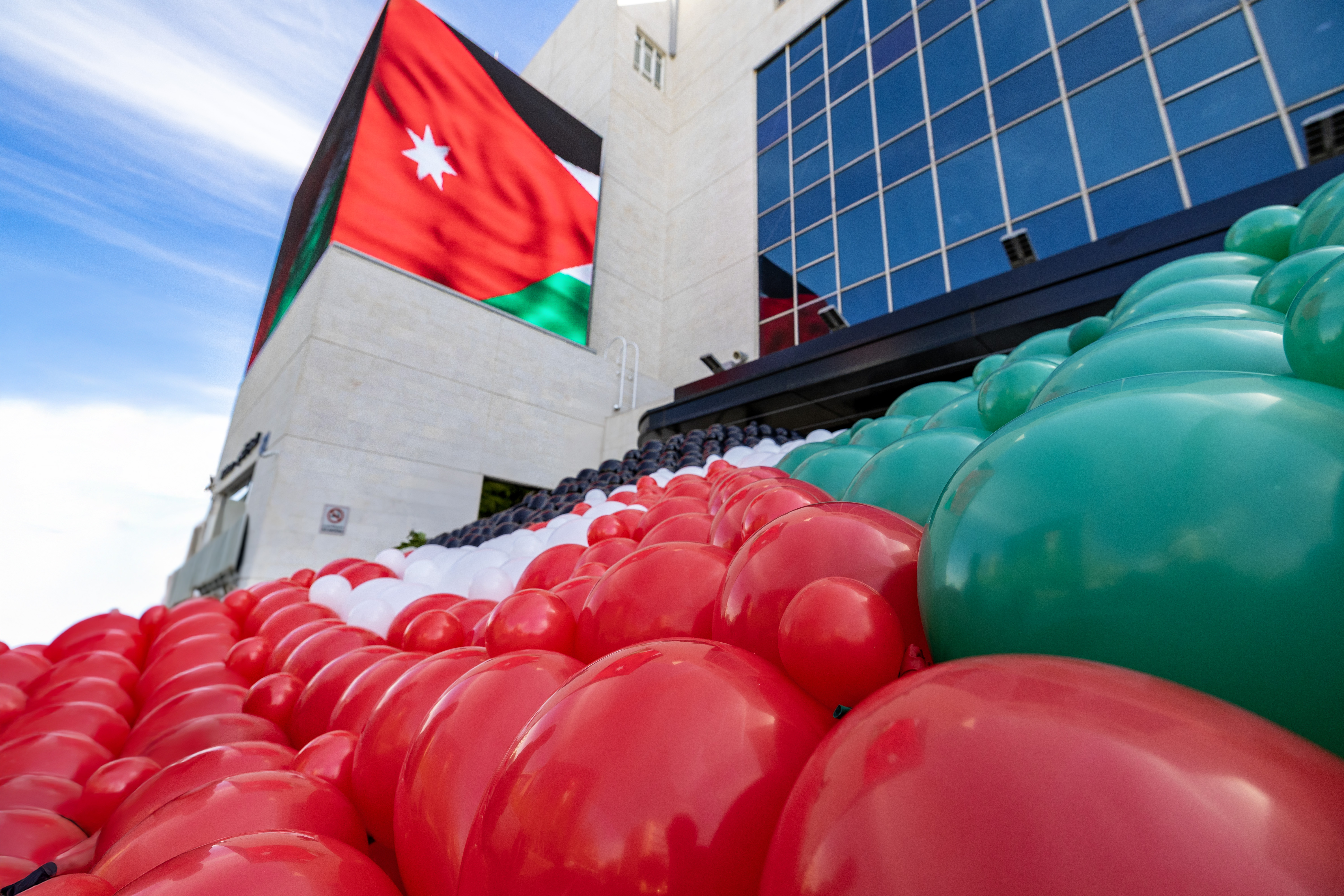 زين تحتفي بيوم العلم الأردني وتطلق علماً ضخماً في سماء عمّان  ..  فيديو
