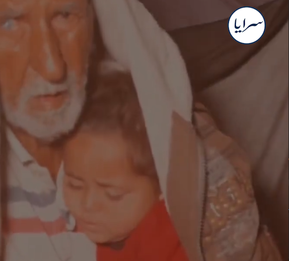 في مشهد مؤلم ..  طفلة تحتمي بجدّها داخل خيمة تغمرها الأمطار في خان يونس (فيديو)