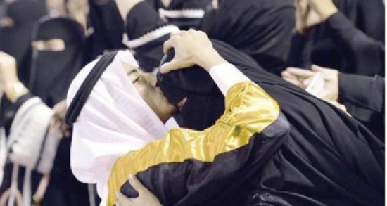 شاب يقبل جبين والدته ويلبسها عقاله في حفل تخرجه من الجامعة .. صورة