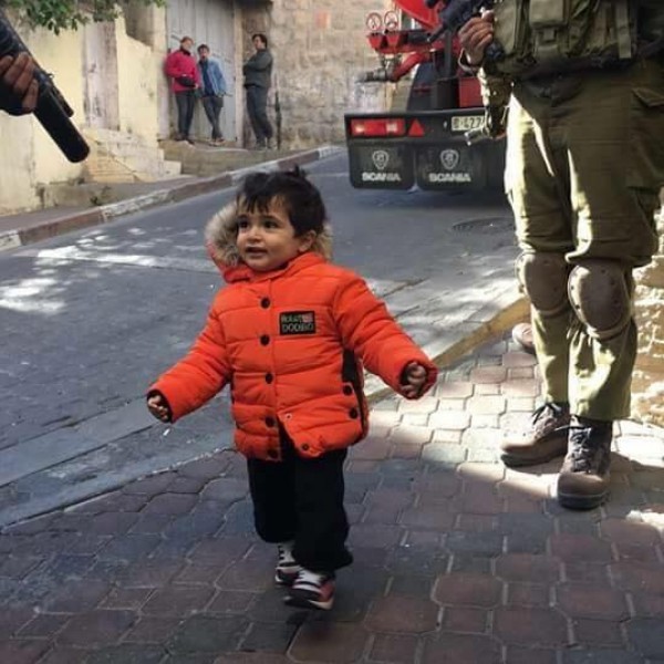 صور .. طفلة فلسطينية في الخليل تثير اهتمام الفيسبوك:"البراءة تتصدى للبندقية"   
