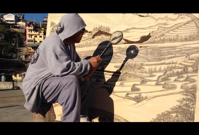 بالصور ..  فنان يرسم لوحاته بضوء الشمس