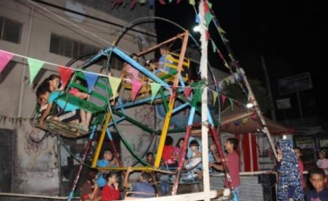 بالصور  ..  مراجيح العيد تتجهز بالزينة لإستقبال راكبيها
