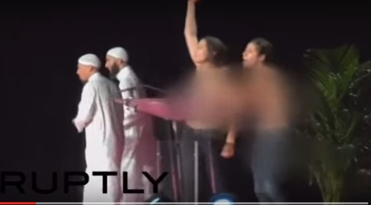 بالفيديو  ..  امرأتان شبه عاريتين تقتحمان مؤتمراً إسلامياً بفرنسا  ..  والحضور يردون بضربهن بقوة 