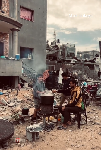 عائلة من غزة يعدون الطعام فوق ركام منزلهم 