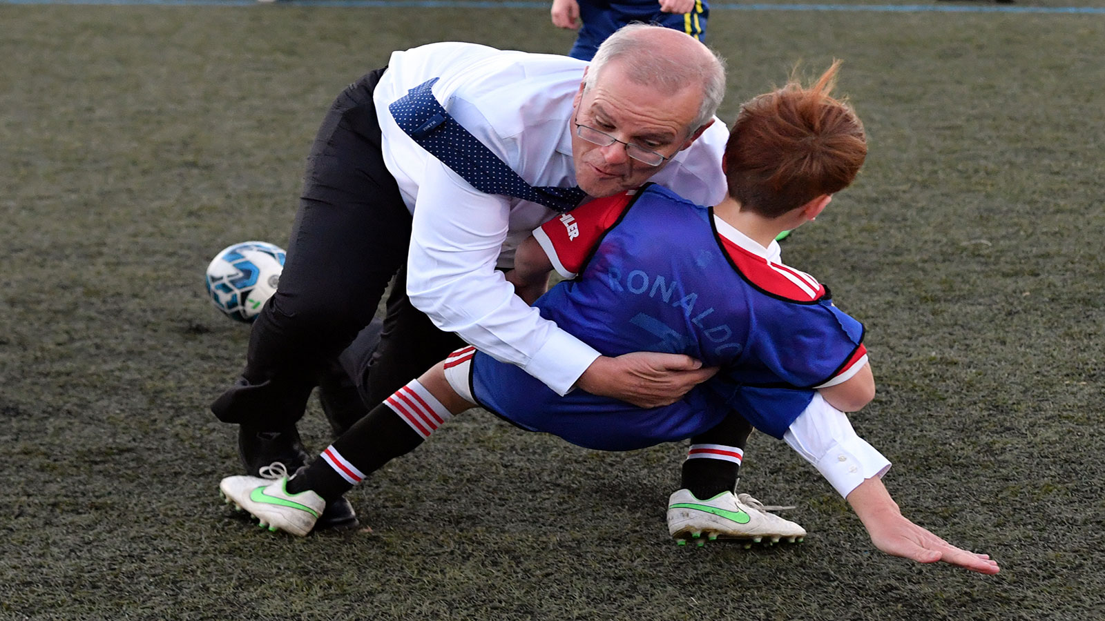 طفل يُسقط رئيس وزراء أستراليا أرضاً في مباراة لكرة القدم ..   فيديو 