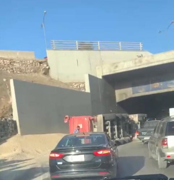 تدهور مركبة شحن وسقوط حمولتها في الشارع العام عند نفق الملتقى بعمان