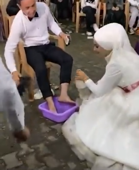 بالفيديو ..  عروس تغسل أقدام عريسها خلال زفافهما