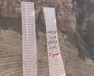 بالفيديو  ..  لبنانيون يعلقون لائحة بأسماء شهداء غزة على صخرة الروشة
