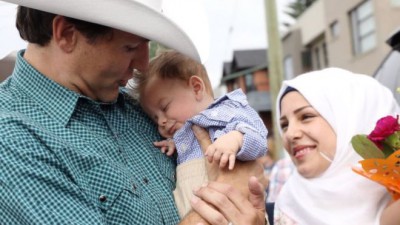 رئيس وزراء كندا يحتضن ويتصور مع الرضيع السوري الذي يحمل إسمه
