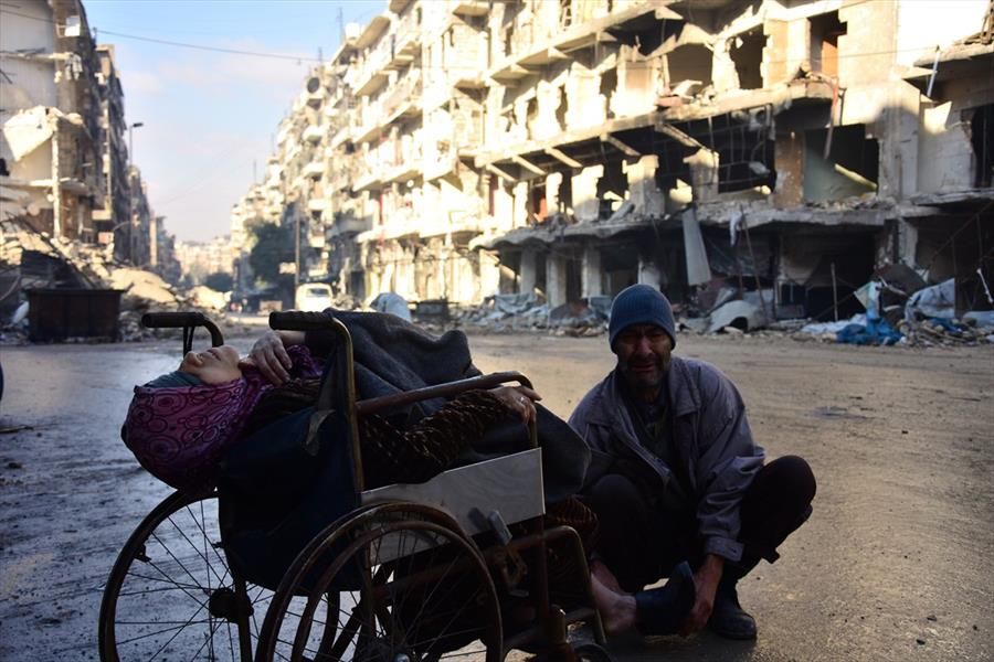 بالصور  ..  "مُسنة" سورية توفيت في حلب على كرسي متحرك امام الكاميرات قبل أن يودع زوجها اولاده السبعة بقصف جوي
