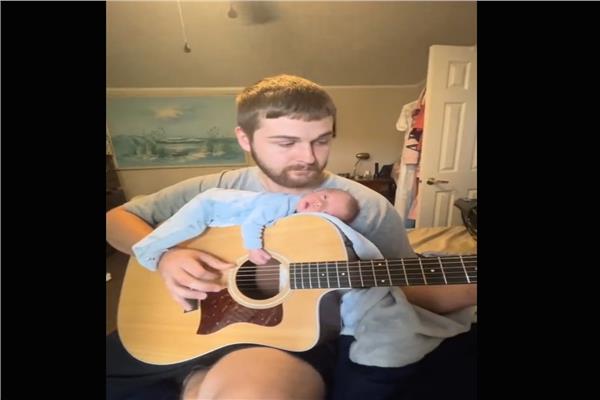 فيديو طريف لأب يضع طفله على جيتار لينام بسهولة