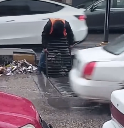 عامل وطن يقوم بتنظيف شبكات تصريف مياه الأمطار في شوارع مدينة إربد - فيديو