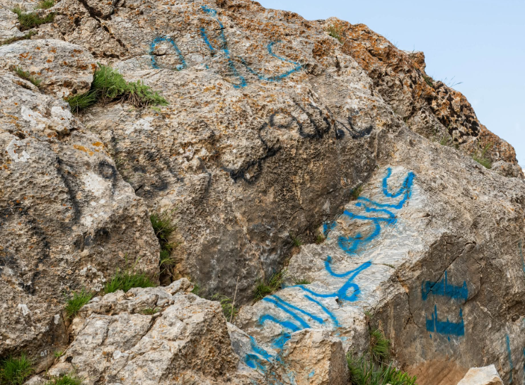 تشويه صخرة أثرية في أربيل بكتابات عربية وأجنبية 