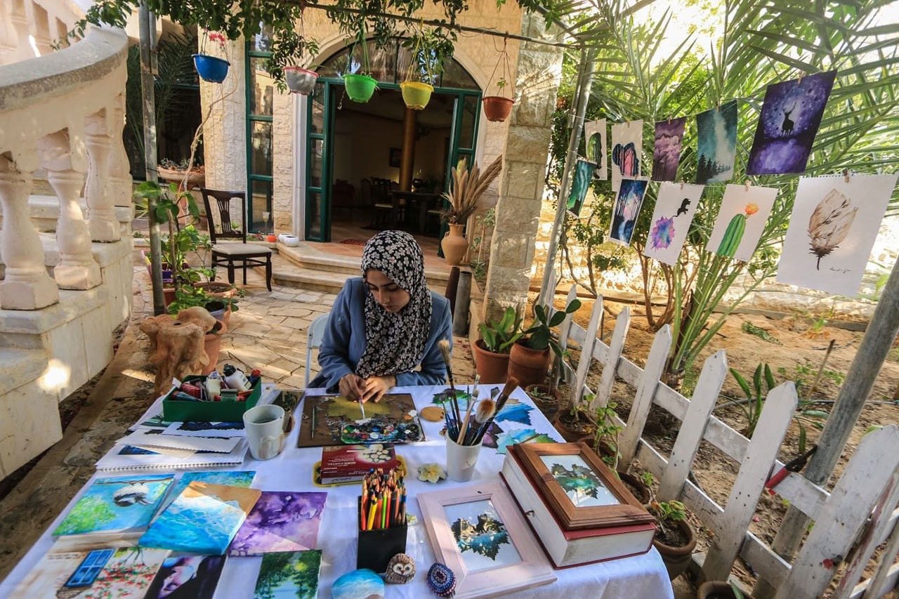 فتاة تجسد الطبيعة الفلسطينية على أوراق العنب
