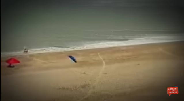 تطاير مظلات لحظة هبوب رياح قوية على الشاطئ