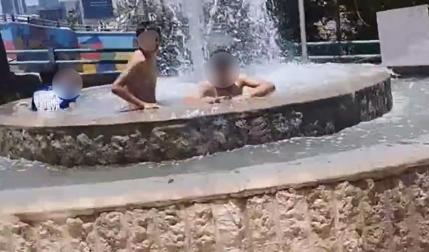 فيديو طريف  ..  أطفال يواجهون حر الشمس بالاستحمام داخل نافورة الدوار الثالث 